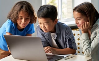 Three kids using a laptop together